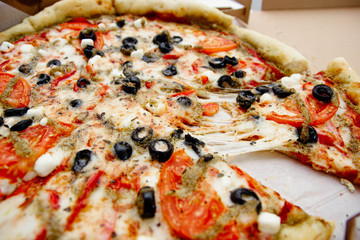 vegetarian pizza with olives, tomatoes and cheese.