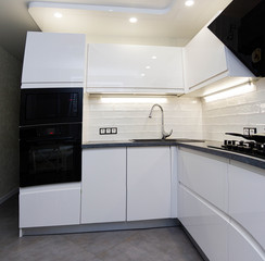 interior of a modern white kitchen with built-in appliances.
