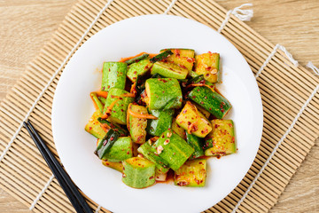 Kimchi cucumber on white plate with chopsticks, Korean food