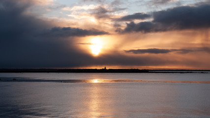 Stunningly beautiful sunrise, taken on a cloudy morning from Salthill beach near Galway, Ireland. Showing the calm water of Galway Bay and Mutton Island in the distance.