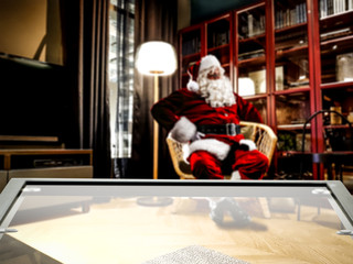 Coffee glass table of free space and red old santa claus in home interior. 