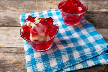 Red jelly with condensed milk on wooden background