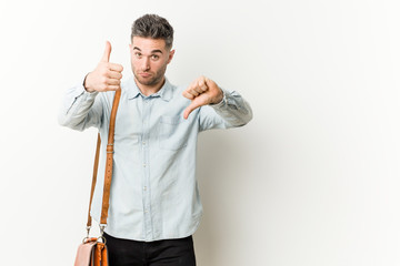 Fototapeta premium Young handsome business man showing thumbs up and thumbs down, difficult choose concept