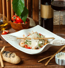 shrimp caesar garnished with breadstick served with red wine