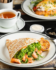 smoked salmon wrap with lettuce, arugula served with grilled lemon