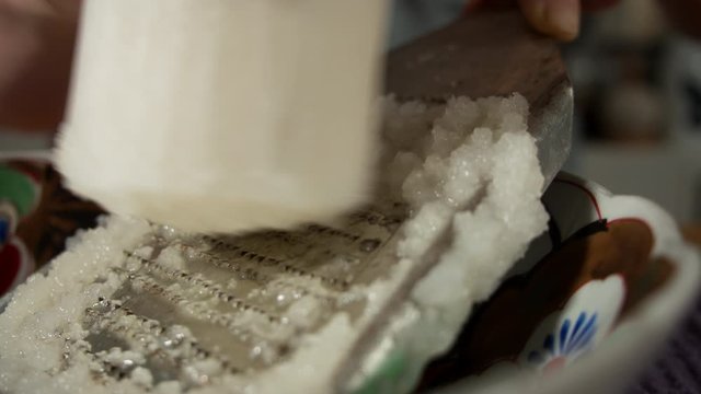 a Japanese female chef grating DAIKON (Mooli) at her home kitchen, Tokyo, Japan. July 2019. Camera fixed, extreme close up, high view, extreme speed shot,