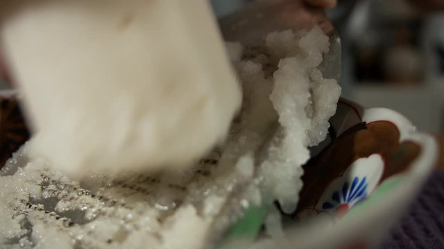 a Japanese female chef grating DAIKON (Mooli) at her home kitchen, Tokyo, Japan. July 2019. Camera fixed, extreme close up, high view,