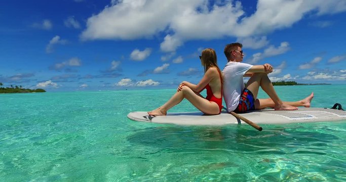 Man and woman relaxing on a swimming boarding over reflecting water, 360 rotating view, Philippines