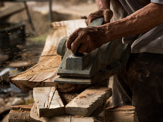 Professional technicians in the factory are using power tools to polish the wooden