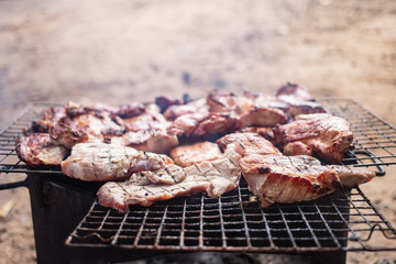 Grilling meat over charcoal stove outdoor