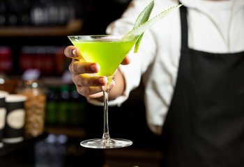 yellow cocktail in barman hand