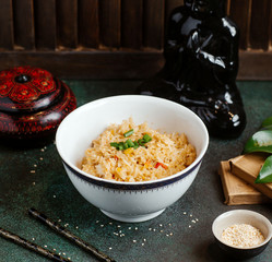 bowl of rice with vegetables garnished with onion chops in chinese restaurant