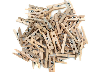 Many wooden clothespins in a pile isolated on white background