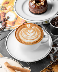 close up of cup of cappuccino coffee and chocolate cake