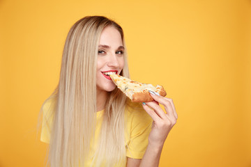 Attractive woman with slice of pizza isolated over the yellow background