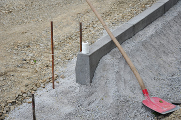 Straßenbau, beim Straßenprojekt mit Hilfe einer Richtschnur Randsteine setzen