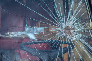 Car accident with shooting concept. Legacy retro car window with signs of shooting a driver.