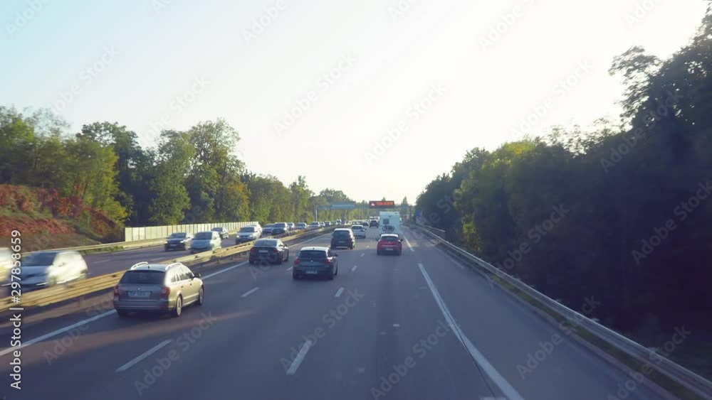 Poster a tracking time lapse of a motorway surrounded with trees and parks, randomly shifting shows of tree