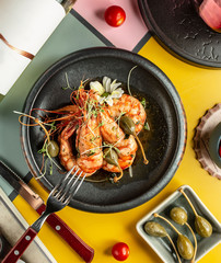 top view of grilled prawns garnished with pickles and flowers