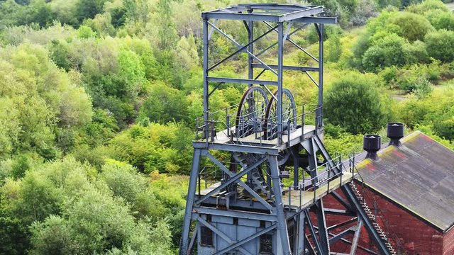 Close up aerial view of ruins of disused coal mine pit head and engine house