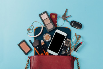 Contents of woman's bag.Top view of Women bag and lady stuff with copyspace on pink background