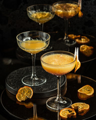 two glasses with long stem of orange cocktail with pulp