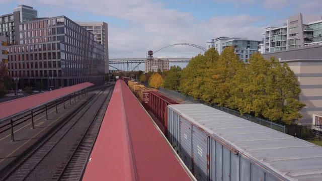 Following a train on its way out of the station into the industrial district of the city.