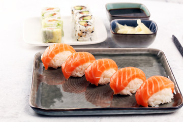 close up of sashimi sushi set with chopsticks and soy - sushi roll with salmon and sushi roll with smoked eel