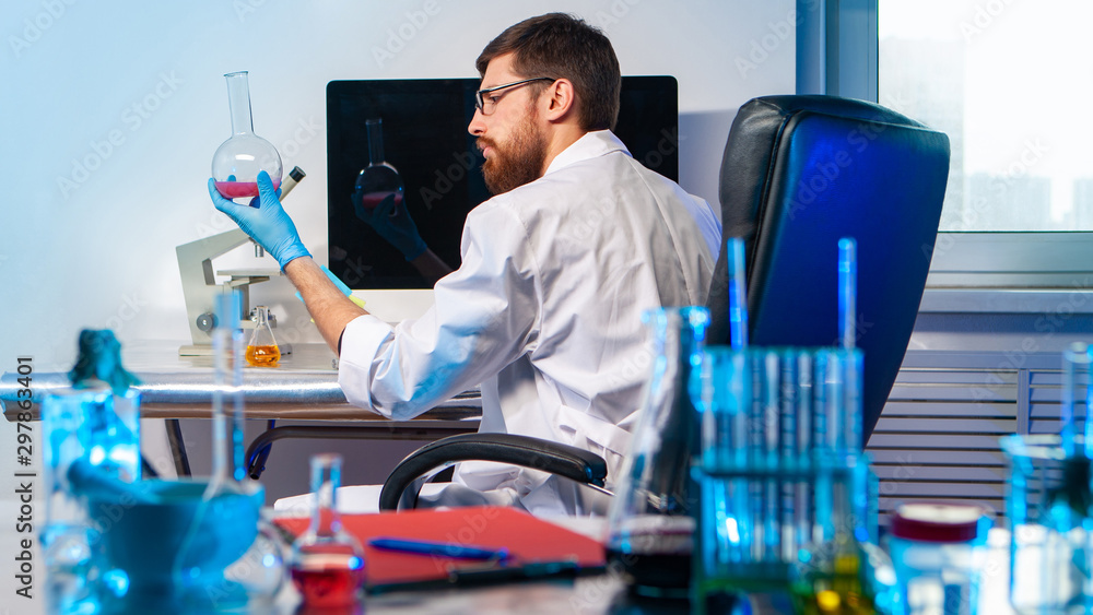 Poster forensic laboratory. lab technician examines a sample. man with a flask in his hands. scientist look