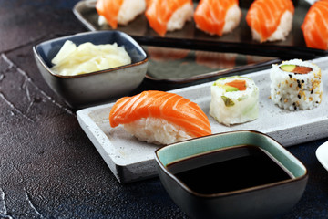 close up of sashimi sushi set with chopsticks and soy - sushi roll with salmon and sushi roll with smoked eel