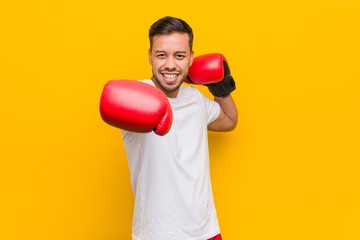 Young south-asian boxer man wearing red gloves.