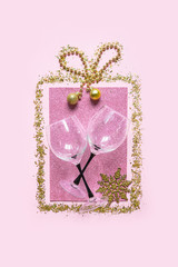 Christmas flat lay composition. Gift box made of glitter on a pink background and filled with Christmas accessories. Set of holiday decorations on a pink background. Holiday card