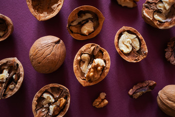 Fototapeta na wymiar Chipped and whole walnuts on a dark background. The concept of healthy organic food. Place for text, top view, flat lay.