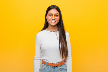 Young pretty arab woman against a yellow background happy, smiling and cheerful.