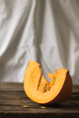 Fresh pumpkin on the table from old boards. Vertical orientation and white background.