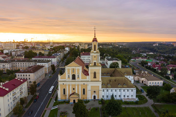 Fototapeta premium Holy Cross Church And Traffic In Mostowaja And Kirova Streets At Evening in the morning light. Grodno city in Belarus. Aerial view from a drone
