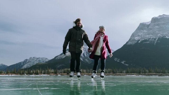 Couple skating together on a frozen lake