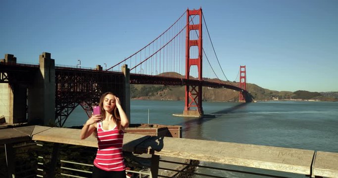 Woman taking selfie with Golden Gate Bridge