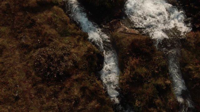 Aerial top down view of a hot spring of water running into the sea in North Iceland