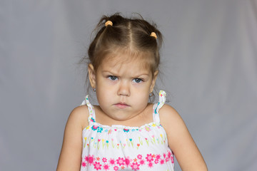 Portrait of very angry little girl on white background