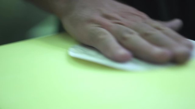 Worker with dirty hands is sanding the top surface with a fine grit circular paper. Slow motion.