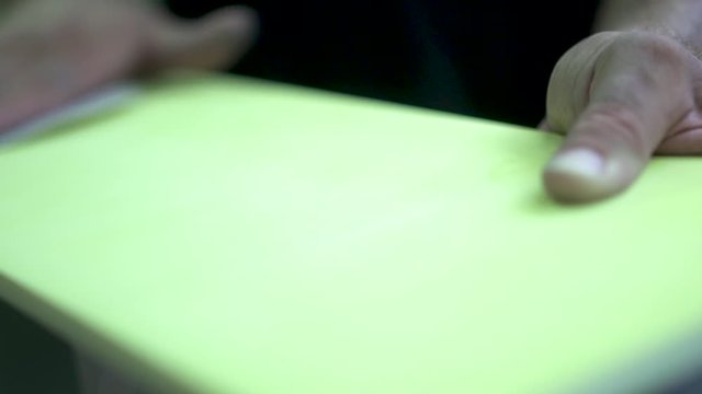 Professional worker sanding out a yellow painted surface. Getting ready to be sent to the next step at the manufacture. Slow Motion. 