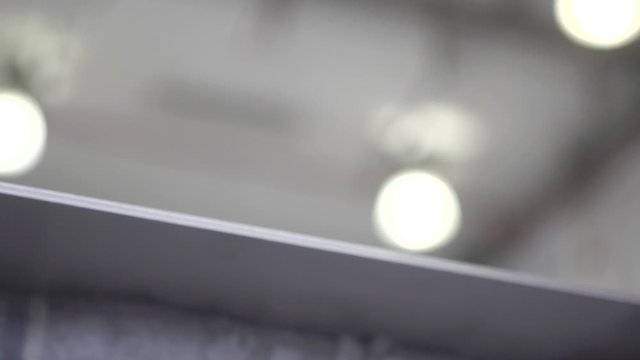 Professional using a sander to smooth out a sheet of aluminium. View from the inside of the workshop. Slow Motion. 