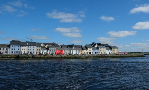 Famous view of the brightly painted houses of Galway city and the River Corrib rushing past on a sunny summer day