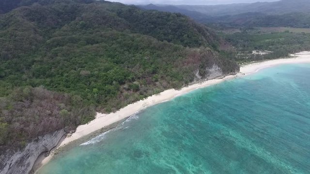 Splendid View on Tropical Island Coast With Cliffs, Sandy Beach and Rainforest, Tilt Up Descending Aerial
