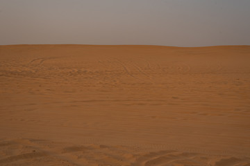 sunset in the vast desert with ripples on the sand