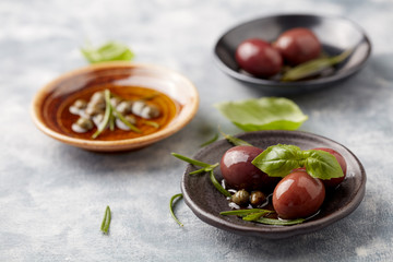 Kalamata olives and capers on bright wooden background. Close up. 