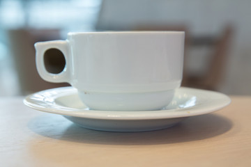 white cup, coffee in white sauce.Cup of hot coffee on table in cafe blur background . coffee beans in white porcelain cup decorated wild herbs .