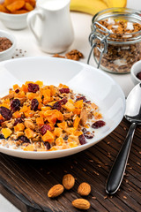Healthy breakfast. Granola muesli with milk, dried apricots, cranberries, almonds and flax seeds. Clean eating, diet, detox, vegetarian food.