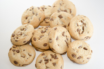 Close up on cookies with dark chocolate chips on the white background. Dessert or pastries